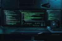 A dark‑mode developer workspace featuring a sleek black laptop with a neon‑green glowing terminal and audio waveform, representing a voice‑enabled AI agent for accessibility.