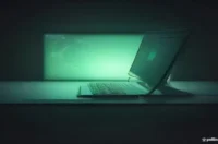 A dark-themed developer setup featuring glowing green terminal code illustrating idempotent retry logic in Go.